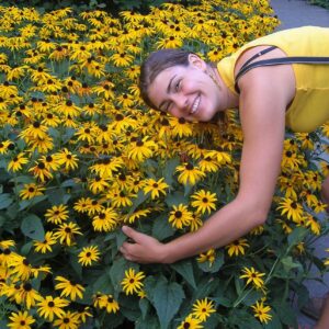 Girl posing with yellow rudbeckia flowers