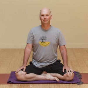 Charlie sitting cross legged on mat for meditation